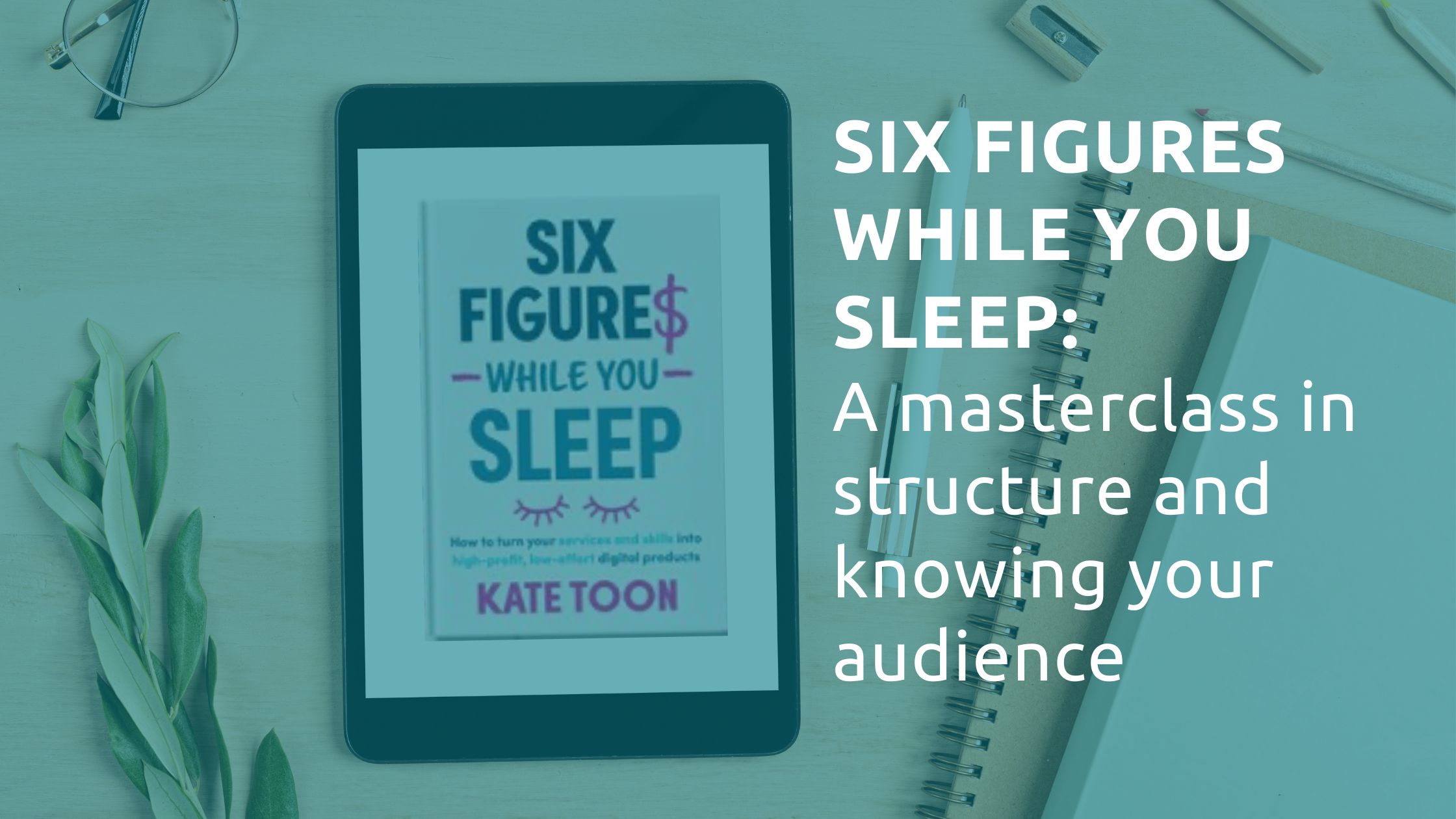 An image showing the front cover of Six Figures While You Sleep on a tablet. The tablet is next some pens and notepads on a desk