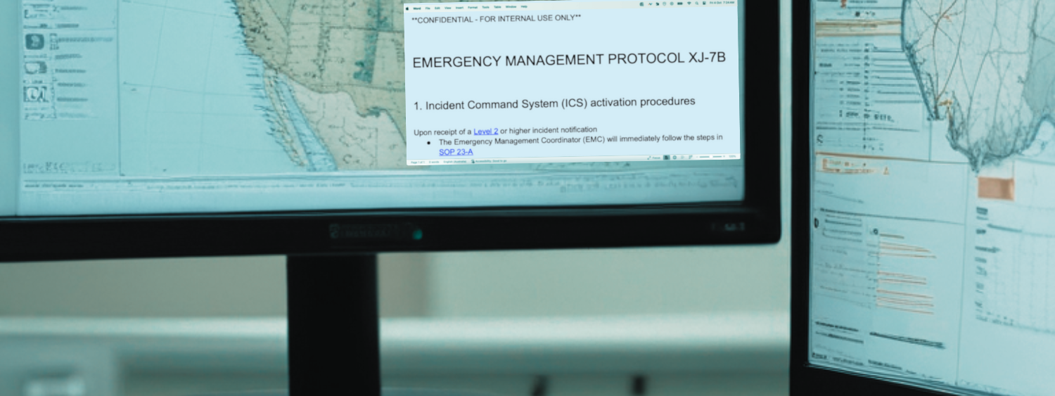 Two computer monitors showing maps and emergency management communications procedure