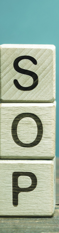 Three wooden blocks with S, O and P on them for standard operating procedures